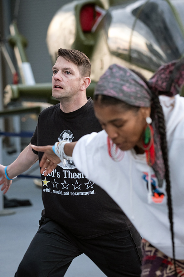 A white man and black woman dance side-by-side on the deck of the Intrepid Museum.