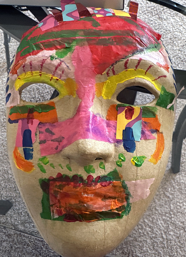 Photo of a mask artwork painted with multiple colors.